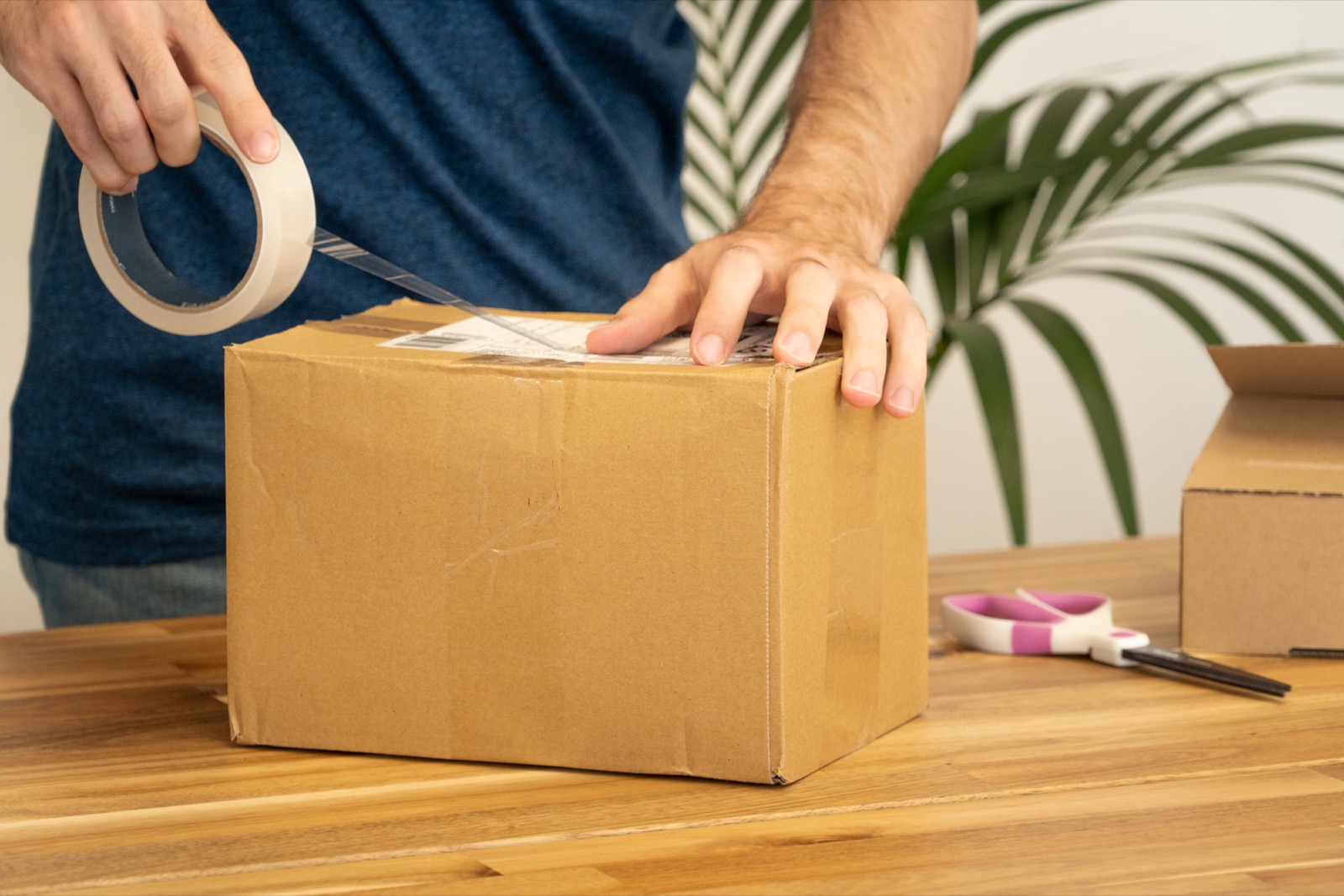 Photo of a shipping label being taped onto a parcel before dispatch, showing why final carton marks should be confirmed before cargo moves.
